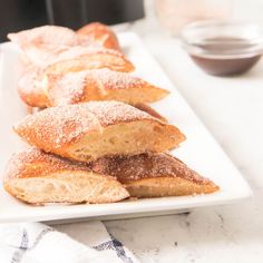 several pastries on a white plate with powdered sugar