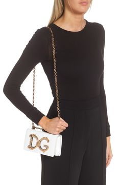 A D&G logo with baroque-inspired gilt flourishes ornately brands this compact leather bag designed with a sliding chain strap that can be worn doubled or long. Magnetic-snap flap closure Pull-through chain strap Interior card slot Leather lining Leather Made in Italy Designer Handbags Elegant Bags With Designer Logo, Elegant Gold Shoulder Bag With Logo, Luxury Clutch Bag With Logo, Elegant Bags With Logo, Leather Bag Design, G Logo, Chain Strap, Leather Bag, Bags Designer