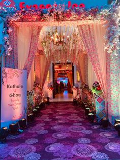 an entrance to a wedding venue decorated with flowers and chandeliers