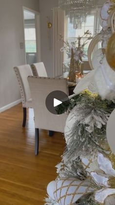 a christmas tree in the middle of a room with white and gold decorations on it