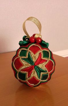 a red and green ornament sitting on top of a wooden table