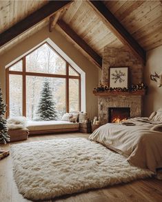 a bedroom decorated for christmas with a large window and fireplace in the corner, along with a white fluffy rug on the floor