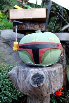 a boba fett pumpkin sitting on top of a piece of wood