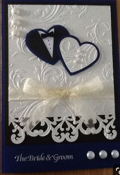 a wedding card with two hearts and a tuxedo on the front in blue