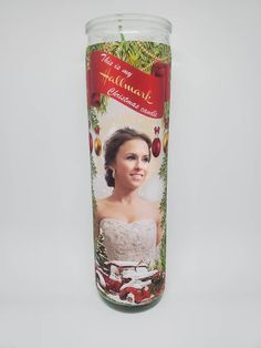 a christmas candle with an image of a woman in a white dress on the front