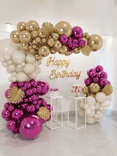 an arch made out of balloons with the words happy birthday in gold and purple colors