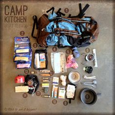 the contents of a camping kit laid out on top of a cement floor next to an open backpack