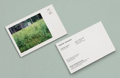 two business cards on top of each other with an image of a field in the background