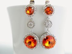 "Handmade Sterling Silver Earrings feature sparkly orange Swarovski crystals that are set in frames designed and made exclusively for Estylo Jewelry. These beautiful earrings are made of Crystallized Elements drops that hang from Sterling post earrings with matching orange Swarovski crystals surrounded by tiny clear Cubic Zirconia stones and round cubic zirconia connectors. They are perfect for a wedding or any other special occasion. They are gorgeous as focal point of your outfit. Also great f Orange Teardrop Jewelry For Wedding, Orange Drop Earrings For Wedding, Orange Cubic Zirconia Jewelry For Anniversary, Fall Wedding Jewelry, Burnt Orange Wedding, Long Crystal Earrings, Long Bridal Earrings, Earring Long, Burnt Orange Weddings