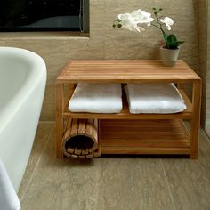 a white flower sitting on top of a wooden shelf next to a bath tub