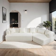 a large white couch sitting in a living room on top of a hard wood floor