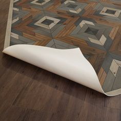 an area rug that is on the ground with wood flooring and white furniture in it