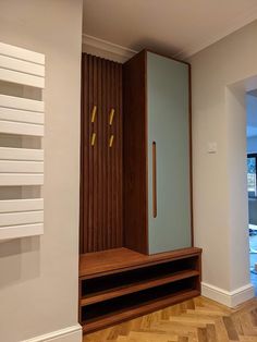 an empty room with a wooden bench and glass door on the wall, next to a radiator