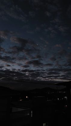 the night sky is dark and cloudy, with some clouds in the distance as well