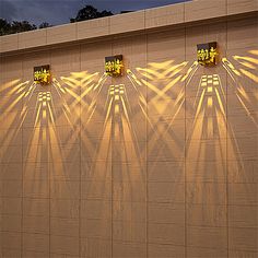 four lights are shining on the side of a building