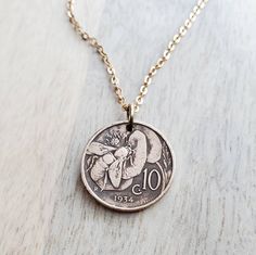 "A necklace crafted with an Italian vintage early 1900's copper coin featuring a honeybee foraging from a flower.  The number 10 appears on the front of the coin.  The reverse reads \"Vittorio Emenvele III Re D'Italia\".  I have cleaned and polished the coin leaving the darkened patina in the recesses.  The coin is a significant, measuring about 7/8\" (about 22 mm) in diameter.  This necklace makes a wonderful gift for a nature loving friend, for someone who is a beekeeper, for someone from Italy, an Italian exchange student and anyone who loves historical coins repurposed into something beautiful!   The chain is a solid red brass cable chain, crafted with a lobster clasp closure.  All chain materials are new deadstock material (vintage, but in new condition) making this entire necklace en Italian Coin Necklace, Charm Necklace Ideas, Historical Coins, Honey Bee Jewelry, Silver Casting, Copper Coin, Packing Ideas, Copper Coins, Number 10