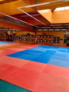 an indoor gym with blue and red mats