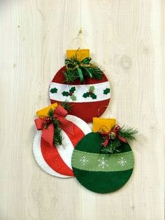 three christmas ornaments hanging on a wooden wall