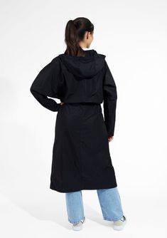 Stay dry and stylish in our women's long black raincoat with a hood. Constructed from a 100% polyester memory fabric, this compact coat is ideal for travel, as it retains it shape after being stuffed into your suitcase. Adjustable drawcords at waist and hood for customizable, feminine styling. Deep inseam side pockets for carrying personal items, impeccably finished with bias bound seaming throughout interior. Water resistant protection from the rain. Built-in travel pocket for packing convenien Stylish Rain Boots, Raincoat With Hood, Long Raincoat, Black Raincoat, Long Rain Coat, Sherpa Vest, Wool Overcoat, Shape Shifting, Hooded Raincoat