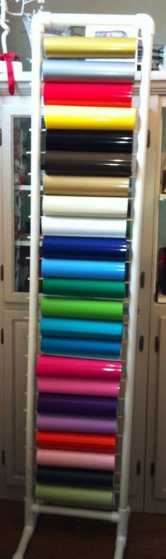 a rack that has many different colored papers on it in front of some cupboards