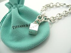 Offered for sale is a wonderful and super cute Tiffany and Co. Sterling Silver 1837 Cube / Box Charm bracelet. The piece is made from substantial and bright Tiffany silver, and yet retains a very feminine feel to it. Attached to its very substantial and bright Tiffany Silver charm bracelet is a super Cool 1837 Cube Padlock charm. The Gift Box padlock charm is permanently attached to the bracelet - so you will not ever have the risk of losing the charm! It is a classic Tiffany piece that will mos Designer Rectangular Bracelets As Gift, Rectangular Bracelet With Box Clasp As Gift, Luxury Silver Jewelry For Birthday Gift, Luxury Rectangular Bracelet As Gift, Luxury Rectangular Bracelet Gift, Designer Silver Jewelry With Original Box, Rectangular Bracelet With Box Clasp For Gift, Designer Silver Jewelry In Original Box, Luxury Jewelry Gift In Original Box