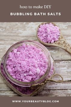 two spoons filled with pink bath salts on top of a wooden table and the words how to make diy bubbling bath salts