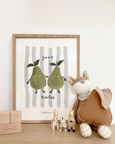 two pears are on the table next to a wooden frame and toy animals in front of it