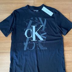 Your Basic Black Tee With A Little Ck Panache. Unisex Shirt But Listed As Men’s Small. Pit To Pit 19”; Length 27” Casual Black Calvin Klein Top, Calvin Klein Black Tops With Letter Print, Calvin Klein Black Casual Top, Calvin Klein Black Top With Letter Print, Calvin Klein Black Cotton Tops, Calvin Klein Graphic T-shirt For Streetwear, Black Calvin Klein Crew Neck T-shirt, Calvin Klein Black T-shirt For Streetwear, White Calvin Klein T-shirt With Logo Print