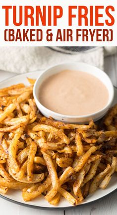 there is a plate with french fries on it and a bowl of dipping sauce in the background