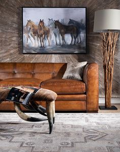 a living room filled with furniture and a painting on the wall