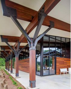 the outside of a building with wooden beams and glass doors on each side of it