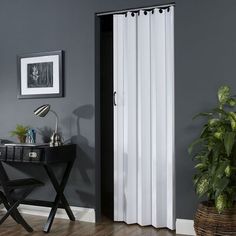 a black and white sliding door in a living room next to a table with a potted plant on it