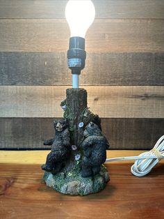 a lamp that is sitting on top of a wooden table next to a bear statue