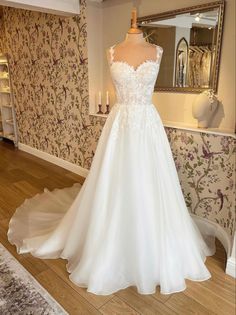 a white wedding dress on display in a room