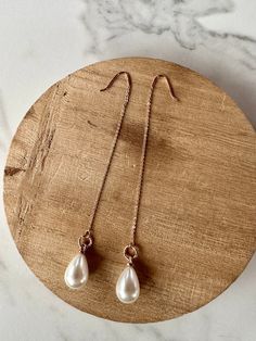 Fine and delicate, these earrings flow from the earlobe in a beautiful rose gold line. These long earrings measure about 5" in length. Hanging from the chains are synthetic pearl teardrop charms. Threader earrings come with wire ends to make it easy to thread the chain through any pierced hole in your ear, making these earrings fun to wear and play around with (from one pierced hole to another). Their versatility is what makes them so popular. They are hypoallergenic and lightweight which makes Elegant Wedding Threader Earrings, Elegant Long Drop Threader Earrings As Gift, Dainty Rose Gold Pearl Earrings For Gift, Dainty Rose Gold Pearl Earrings As Gift, Dainty Rose Gold Linear Earrings As Gift, Elegant Teardrop Threader Earrings As Gift, Dainty Rose Gold Threader Earrings For Gift, Rose Gold Earrings With Delicate Chain For Gift, Rose Gold Earrings With Adjustable Chain As Gift