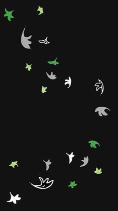 a group of birds flying through the night sky with green and white leaves on them