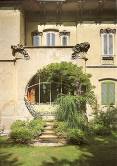 an old building with green shutters on the windows and steps leading up to it