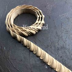 a close up of a wooden bracelet on a black surface