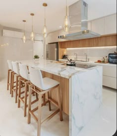 a kitchen with marble counter tops and stools next to an island in the middle