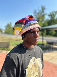 a young man wearing a multicolored knitted hat