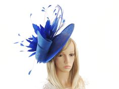 Hats By Cressida Kentucky Derby & Ascot Fascinator Hats Royal Blue Adonis Sinamay & Feather Disc Fascinator Hat Royal Blue sinamay swirls trimmed with a mass of royal blue feathers and curled burnt feathers on a large royal blue sinamay base The hat base measures about 12 inches wide This fascinator is mounted with matching headband If you prefer a headband to match your hair, please make a note at check out what colour headband you want. For those who love to make a statement, the Adonis Fascinator Hat is a perfect choice. This headpiece was designed to add a touch of elegance and glamour to formal events, making it a must-have for those attending Royal Ascot or other hat-centered race events in Melbourne. Featuring a gorgeous saucer disc and an intricate feather arrangement, it is also a Blue Headpieces For Church In Spring, Blue Costume Hats And Headpieces For Church, Blue Costume Hat For Church, Blue Fascinator For Royal Ascot, Blue Fitted Fascinator For Wedding, Blue Wide Brim Fascinator For Parties, Adjustable Blue Headpiece For Races, Adjustable Blue Headpieces For Races, Fitted Blue Mini Hats For Church