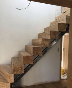 a wooden stair case with metal handrails