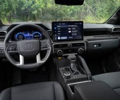 the interior of a car with dashboard, steering wheel and dash board showing various electronic devices