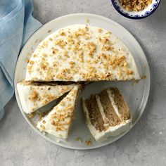 a cake with white frosting and crumbled toppings sits on a plate