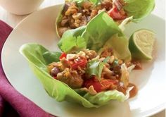 lettuce wraps filled with meat and vegetables sitting on a white plate, ready to be eaten