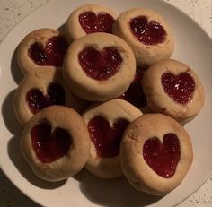 heart shaped cookies on a plate with jam in the middle