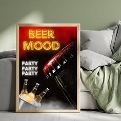 a beer poster is on the floor next to a couch with pillows and throw pillows