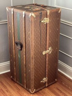 an old suitcase is sitting on the floor in front of a wall and wooden floors