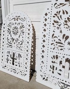 two white laser cut out doors sitting next to each other