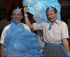 two men in blue costumes are holding up their hands and posing for the camera with one another